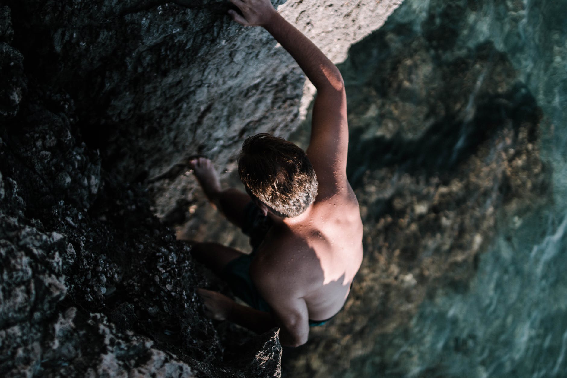 man climbing on cliff