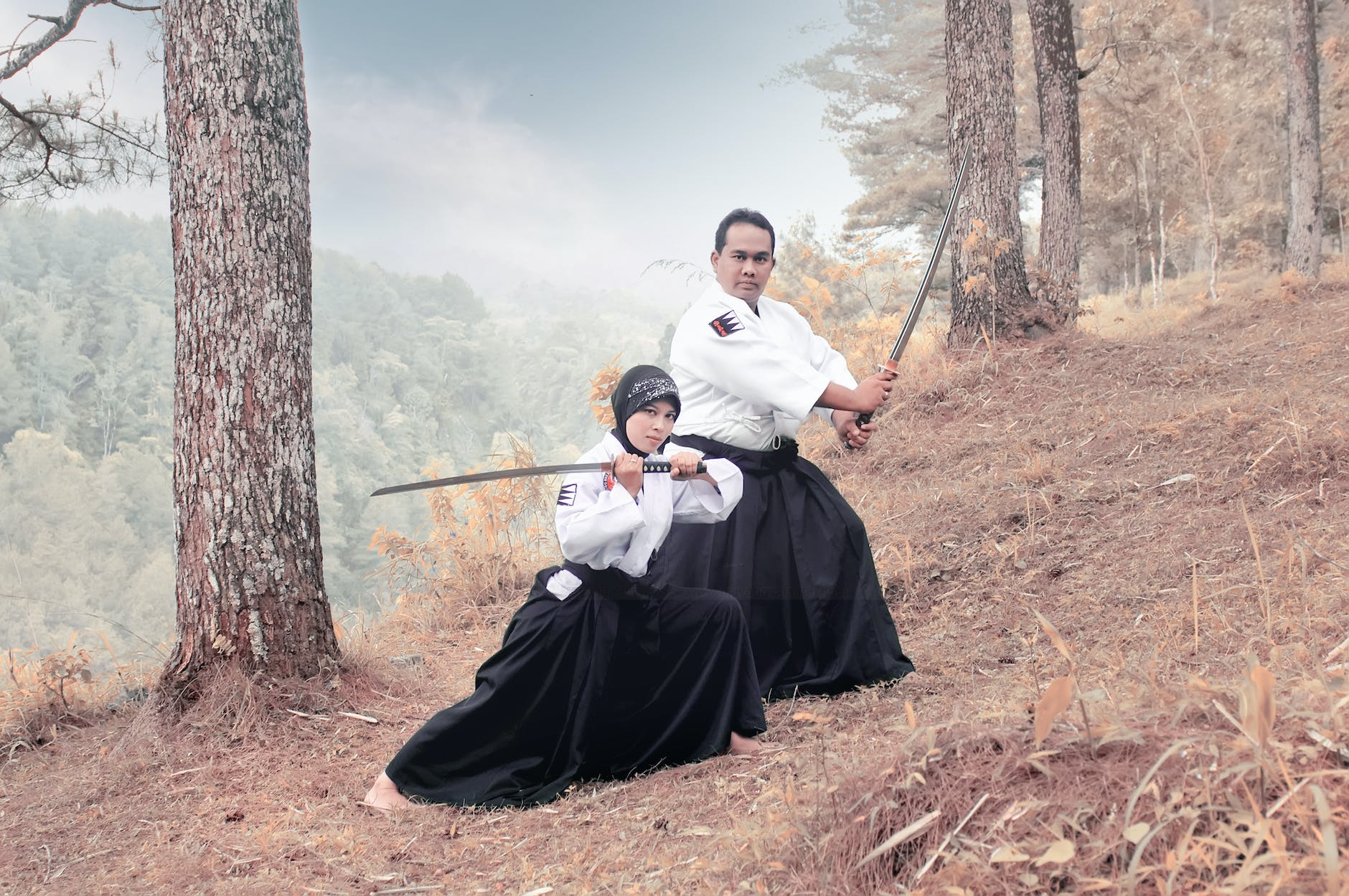 full shot of a man and a woman holding katana swords